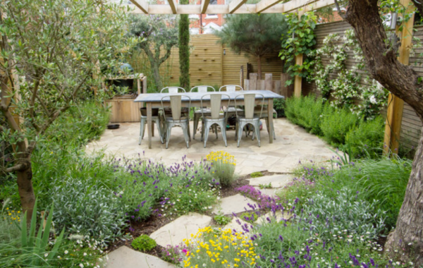 Taman dengan area barbekyu dan ruang makan terbuka di tengah-tengah tanaman